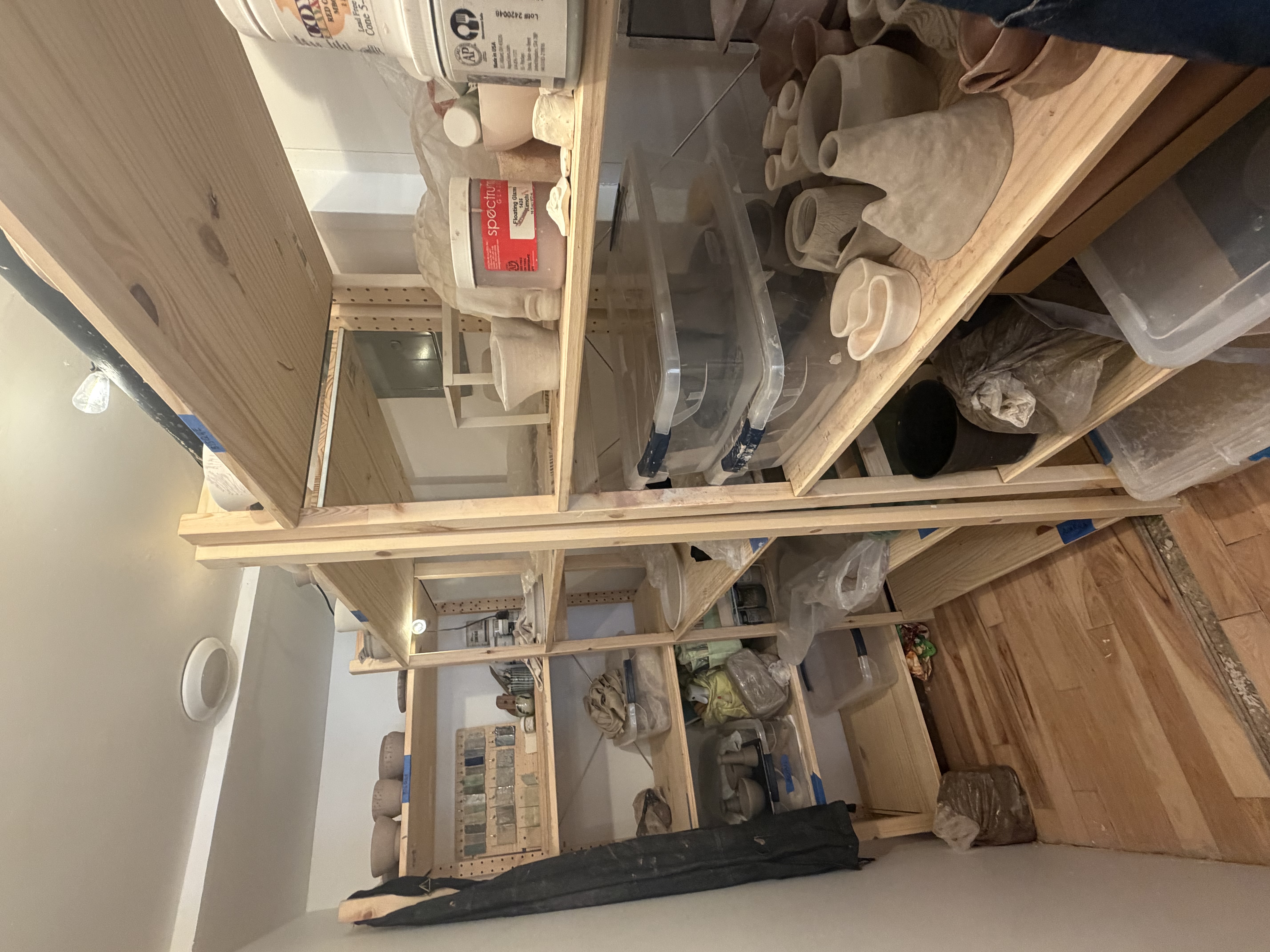 Studio shelves with pottery and supplies
